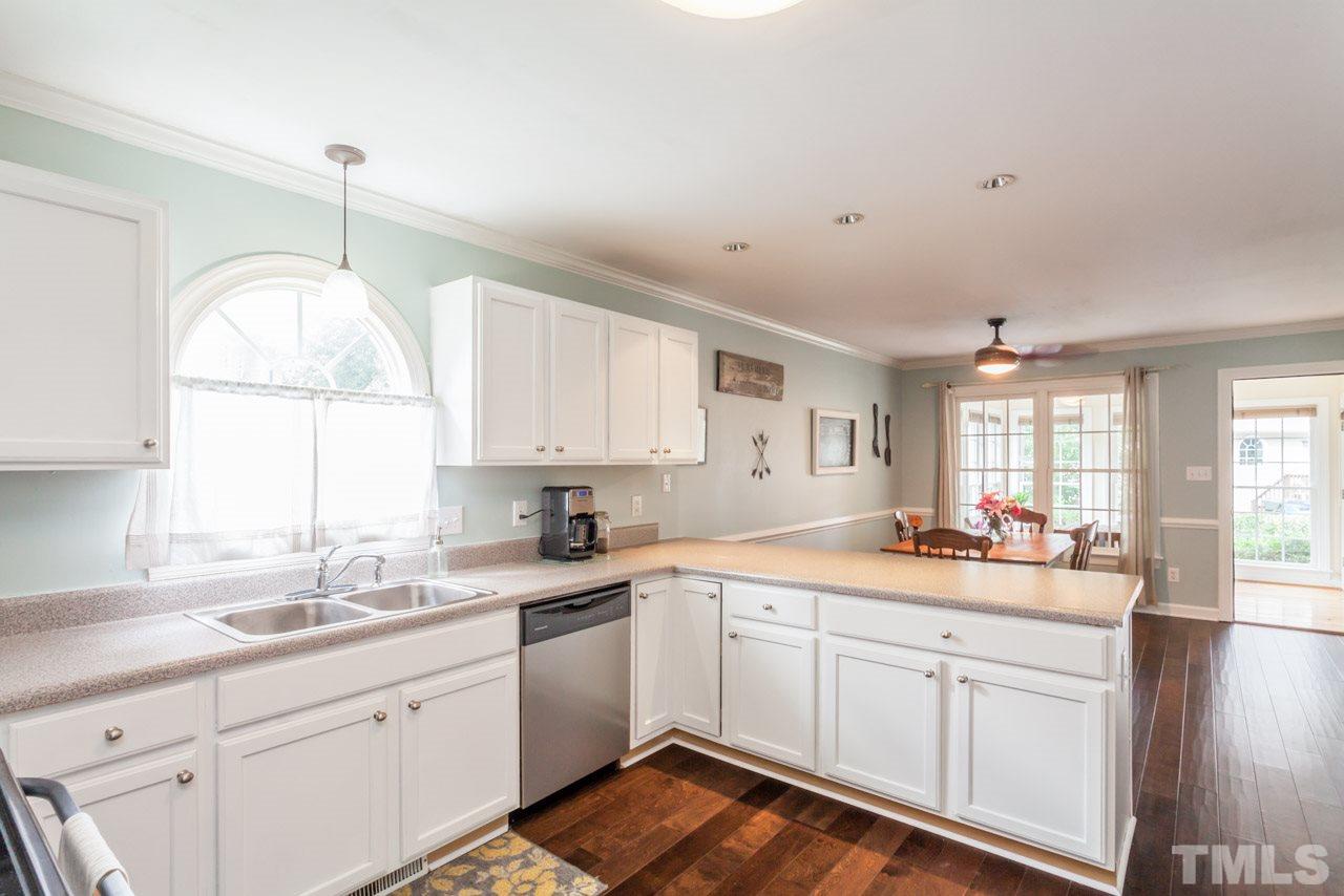 4405 Bartholomew Circle Raleigh, NC 27604 - Photo 8 of 22 a kitchen that has a lot of white cabinets and a wooden floor