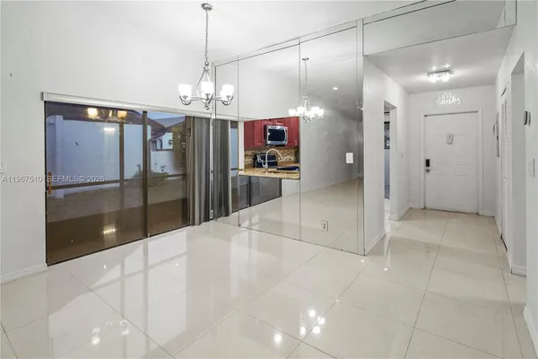 a view of a hallway with wooden floor and a kitchen space