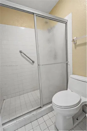 a white toilet sitting next to a shower