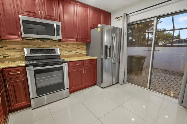 a kitchen with stainless steel appliances granite countertop a refrigerator and a stove top oven