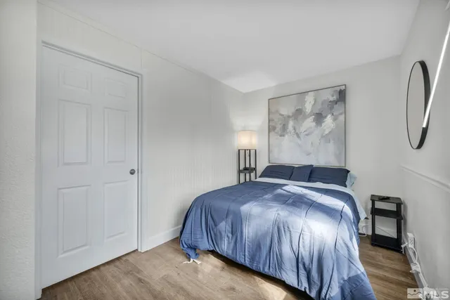 a bedroom with a bed and a painting on the wall