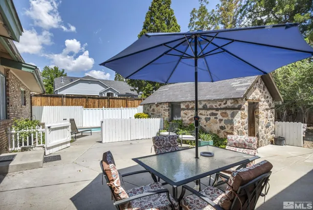 a patio with a table and chairs under an umbrella