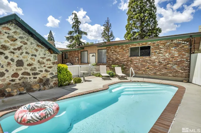 a backyard of a house with table and chairs