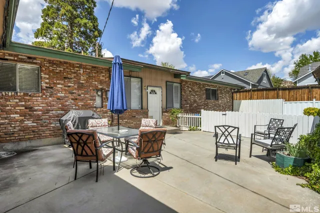 a view of a house with backyard and sitting area