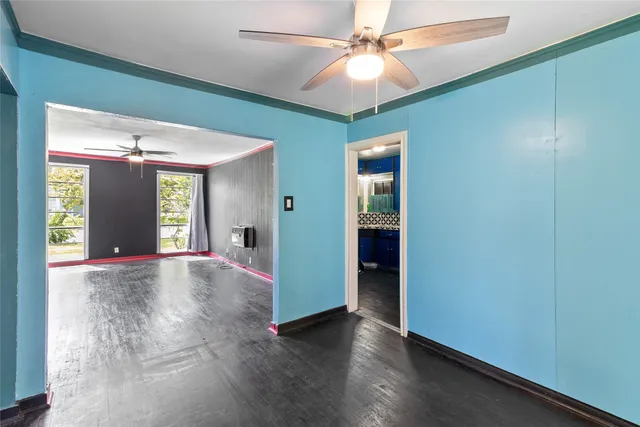 an empty room with fan and entrance