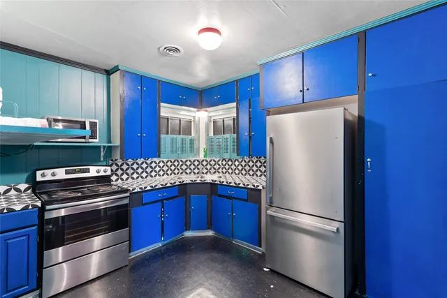 a kitchen with stainless steel appliances a refrigerator and a stove top oven