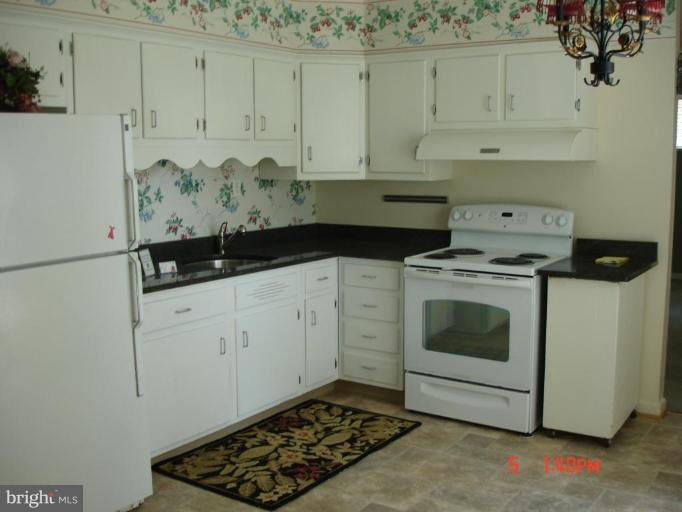 12910 Bluhill Road Silver Spring, MD 20906 - Photo 3 of 10 a kitchen with white cabinets and white appliances