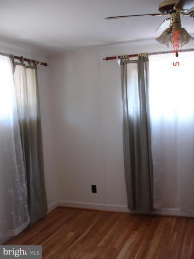 12910 Bluhill Road Silver Spring, MD 20906 - Photo 5 of 10 a view of an empty room with wooden floor and a window