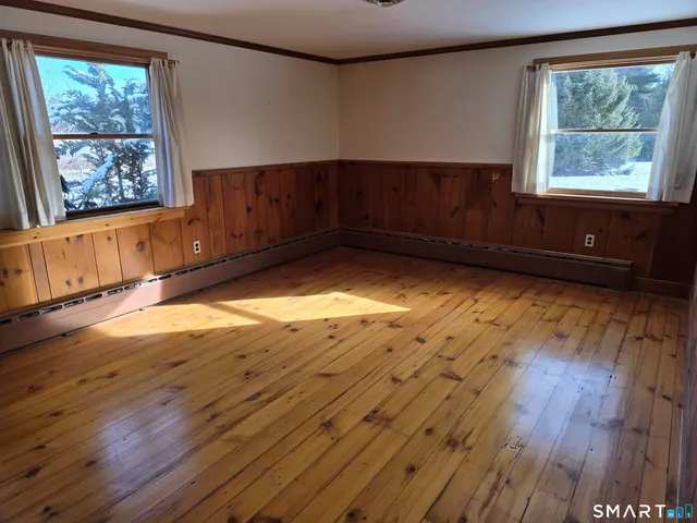a view of a livingroom with wooden floor and window