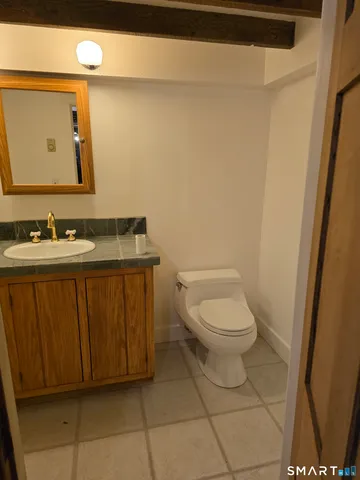 a bathroom with a toilet a sink and mirror