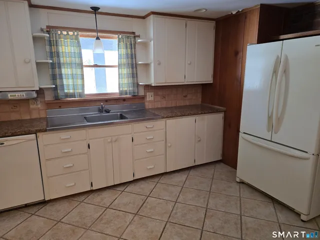 a kitchen with a refrigerator a stove a sink and a window