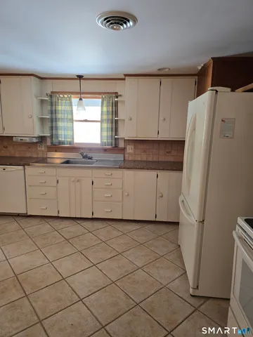 a kitchen with a refrigerator sink and cabinets