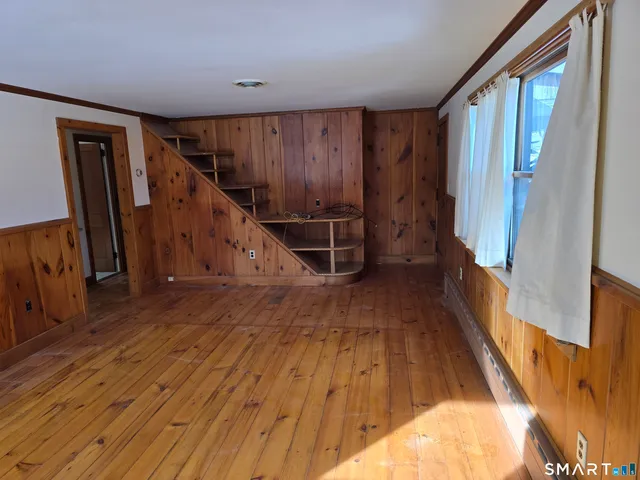 a view of a hallway with wooden floor and staircase