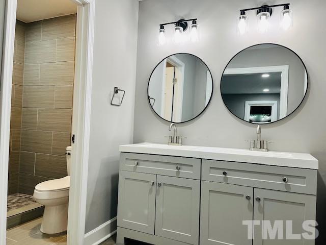 8781 Mill Branch Road Rocky Mount, NC 27803 - Photo 11 of 19 a bathroom with a toilet a sink and mirror