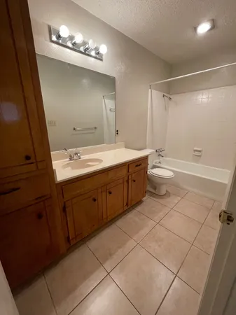 a spacious bathroom with a double vanity sink a toilet and a mirror