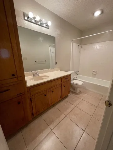 a spacious bathroom with a double vanity sink a toilet and a mirror