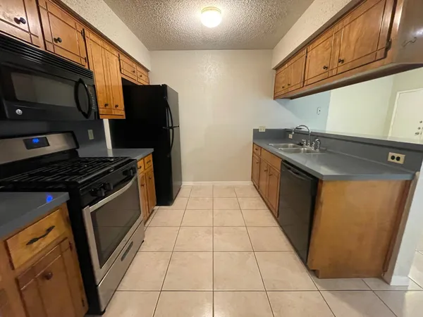a kitchen with stainless steel appliances granite countertop a stove a sink and a microwave