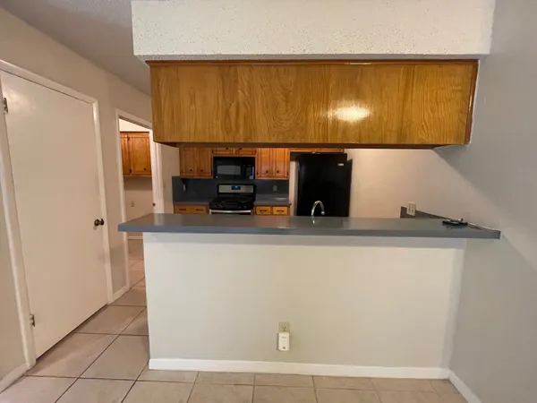 a view of a kitchen with stainless steel appliances wooden floor