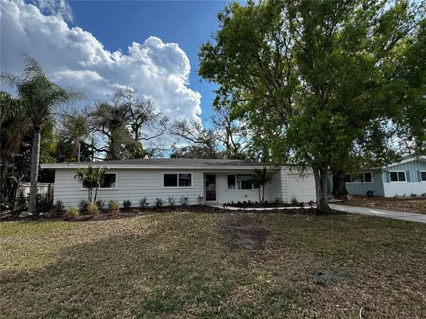 a front view of house with yard and trees around