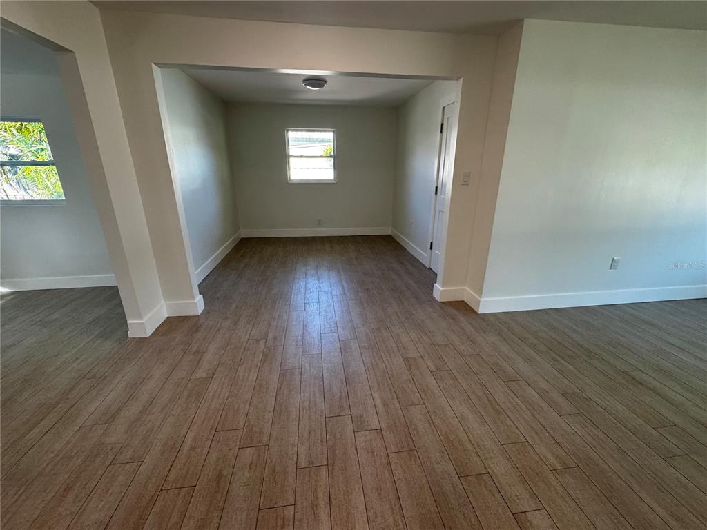 3182 Hatton Street Sarasota, FL 34237 - Photo 11 of 22 an empty room with wooden floor and windows
