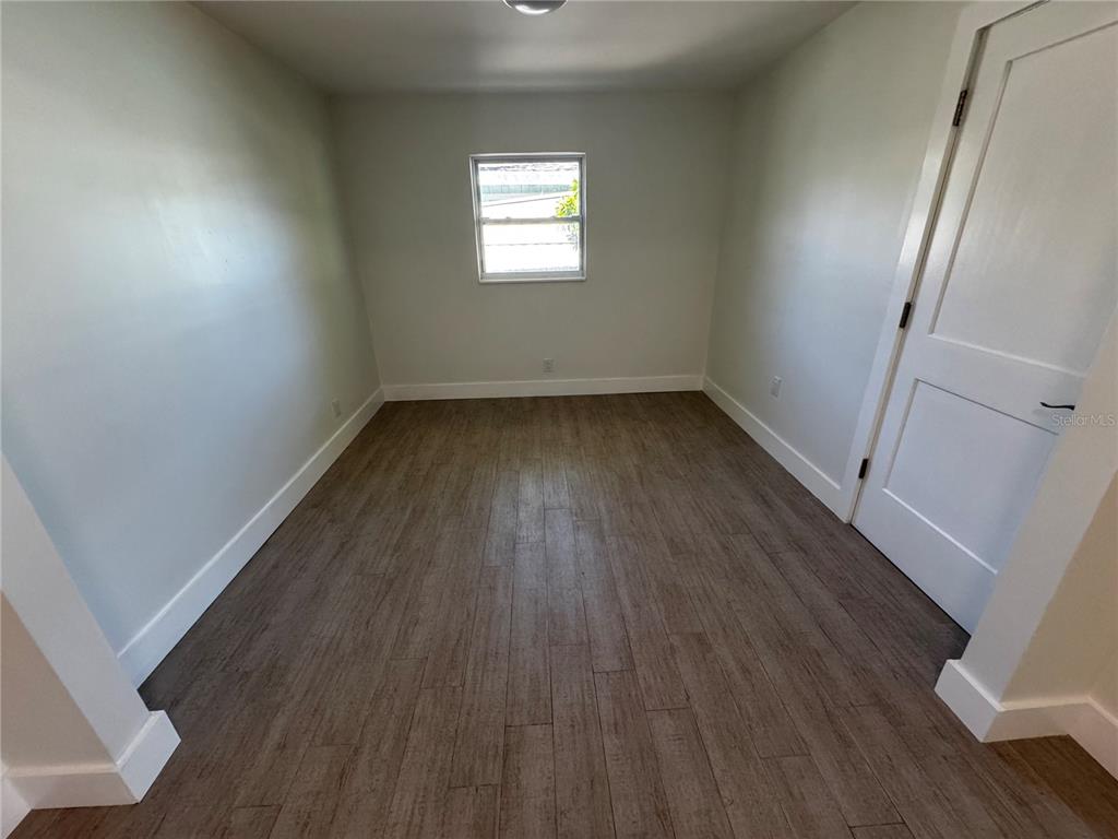 3182 Hatton Street Sarasota, FL 34237 - Photo 12 of 22 an empty room with wooden floor and window