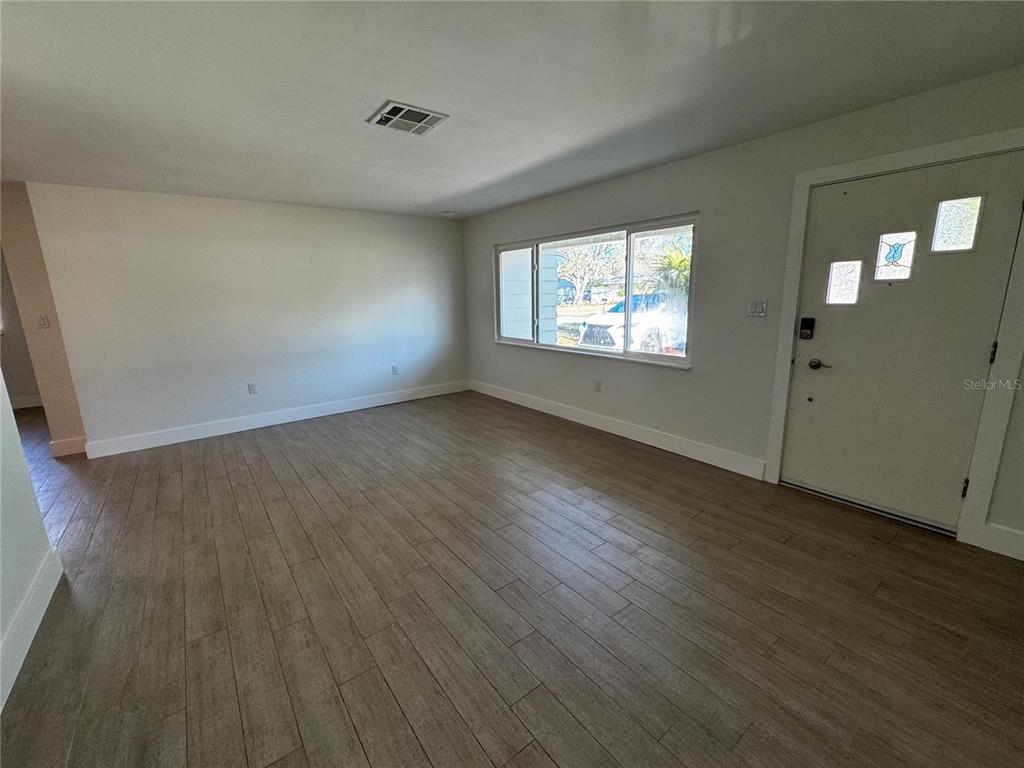 3182 Hatton Street Sarasota, FL 34237 - Photo 8 of 22 an empty room with wooden floor and windows