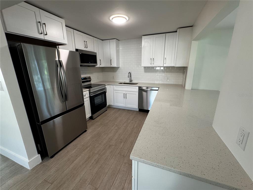 3182 Hatton Street Sarasota, FL 34237 - Photo 9 of 22 a kitchen with stainless steel appliances a refrigerator sink and microwave