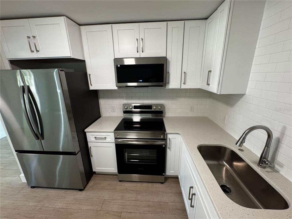 3182 Hatton Street Sarasota, FL 34237 - Photo 10 of 22 a kitchen with stainless steel appliances a refrigerator a sink a stove and a refrigerator