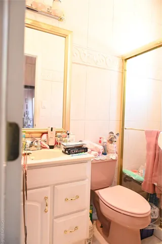 a bathroom with a granite countertop sink toilet a mirror and a window
