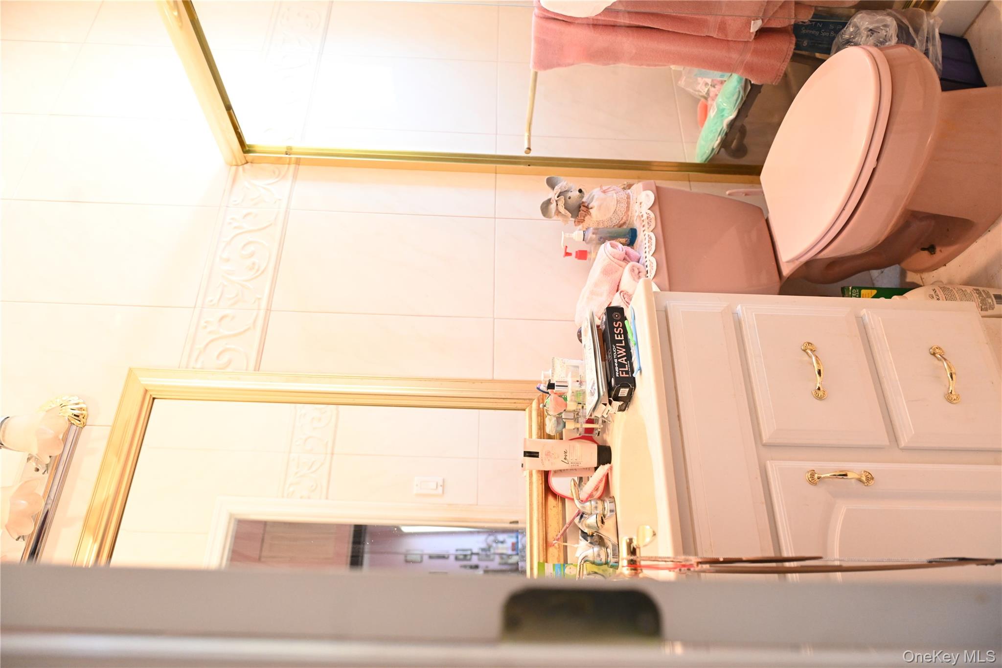 115 Riviera Drive Mastic Beach, NY 11951 - Photo 18 of 27 a bathroom with a granite countertop sink toilet a mirror and a window