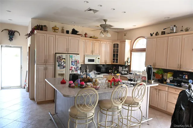 a kitchen with stainless steel appliances kitchen island granite countertop a refrigerator and a sink