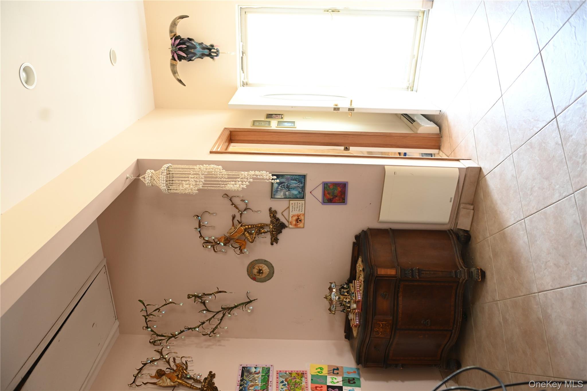 115 Riviera Drive Mastic Beach, NY 11951 - Photo 8 of 27 a living room with a bed and a refrigerator