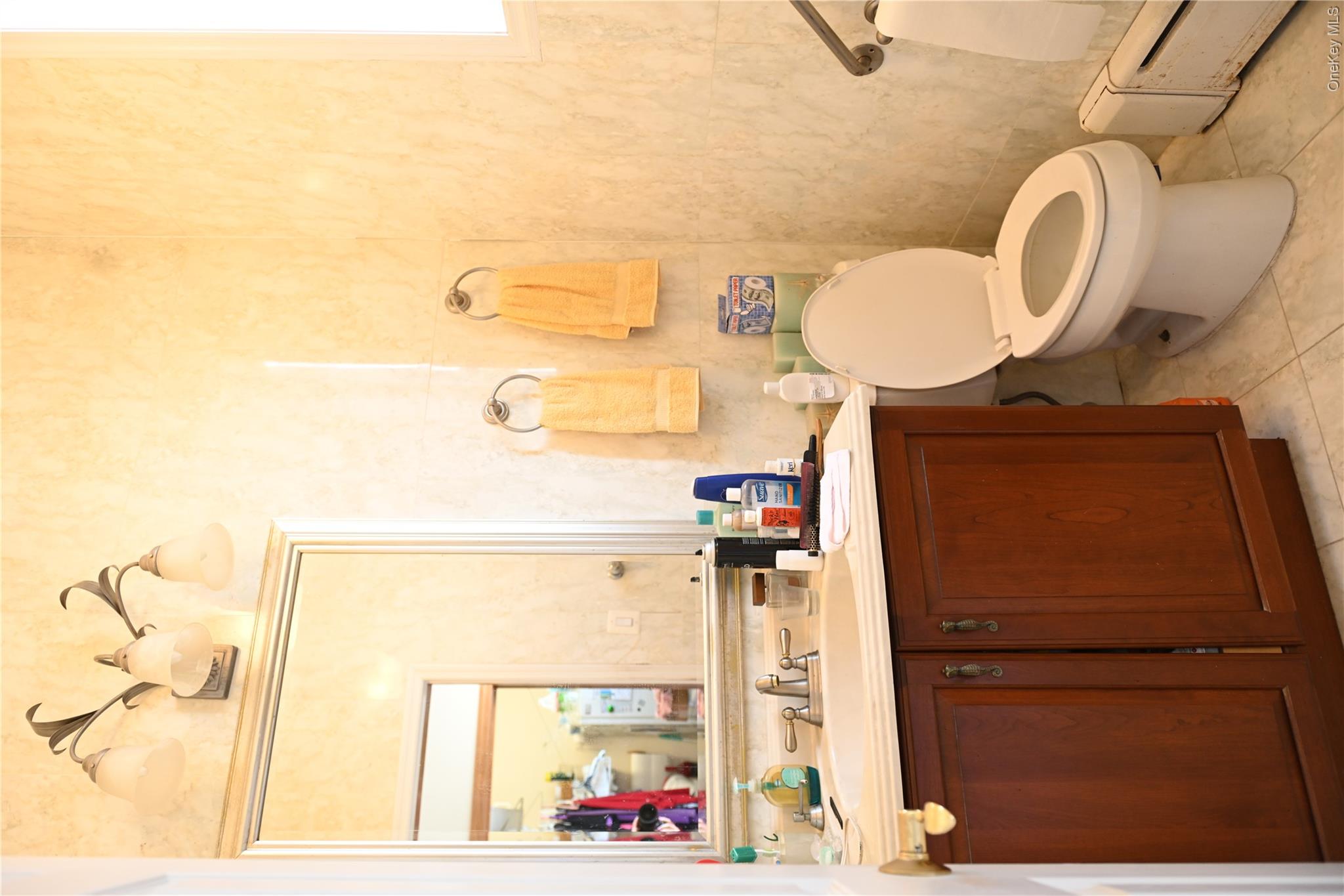 115 Riviera Drive Mastic Beach, NY 11951 - Photo 9 of 27 Half bath featuring vanity, a baseboard radiator, and light tile patterned floors
