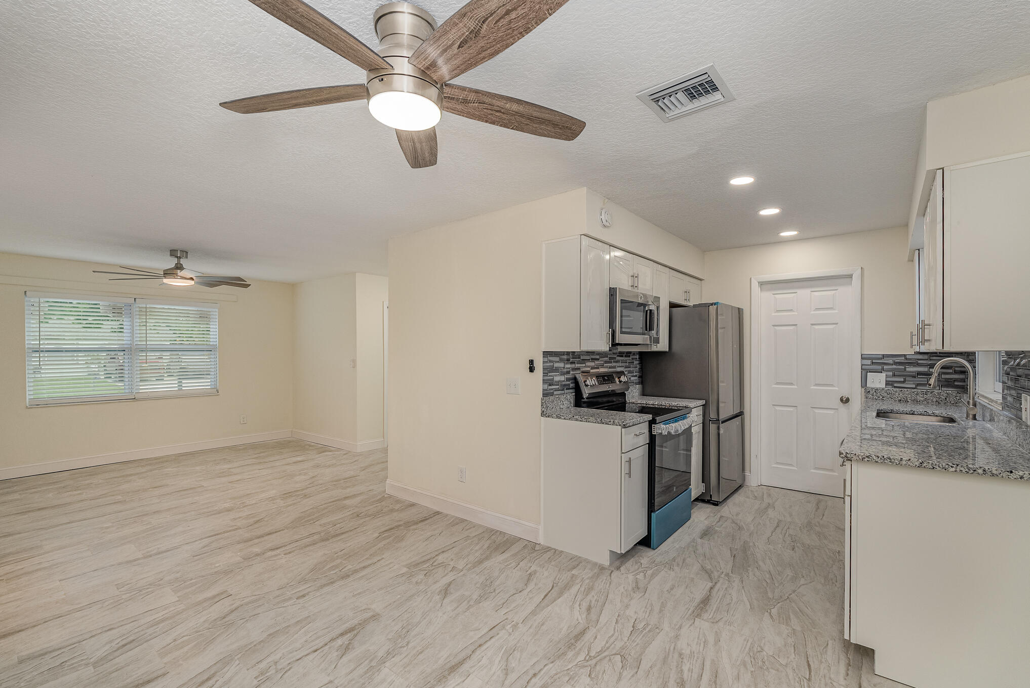 2896 Lancaster Road Melbourne, FL 32935 - Photo 11 of 25 a kitchen with stainless steel appliances granite countertop a stove and a refrigerator