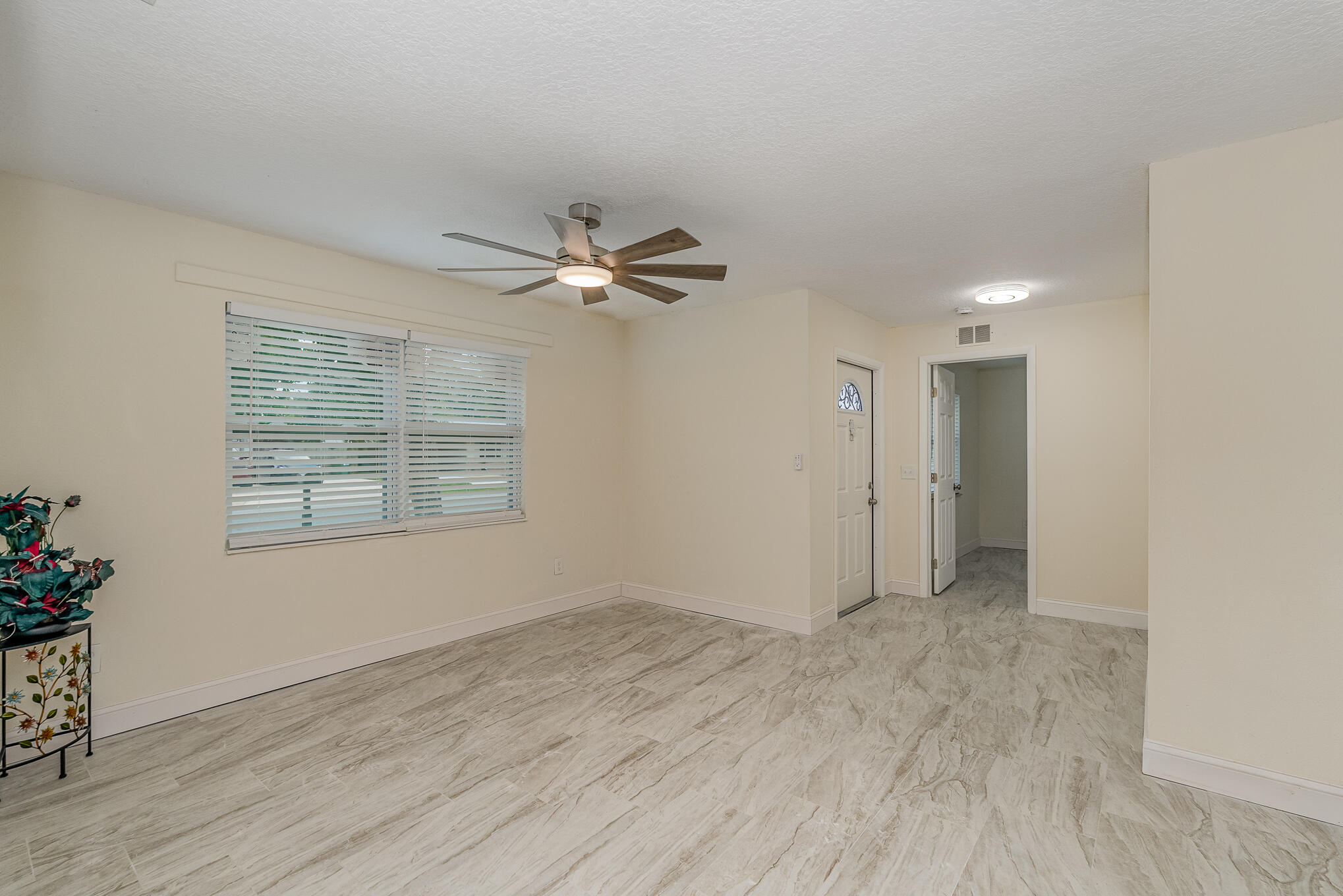 2896 Lancaster Road Melbourne, FL 32935 - Photo 6 of 25 a view of an empty room with wooden floor and a window