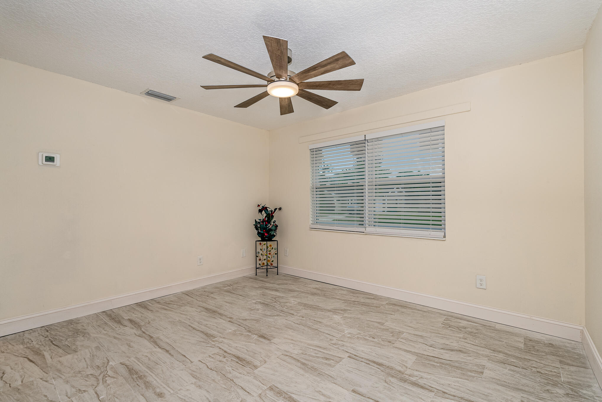 2896 Lancaster Road Melbourne, FL 32935 - Photo 8 of 25 a view of empty room with wooden floor and fan