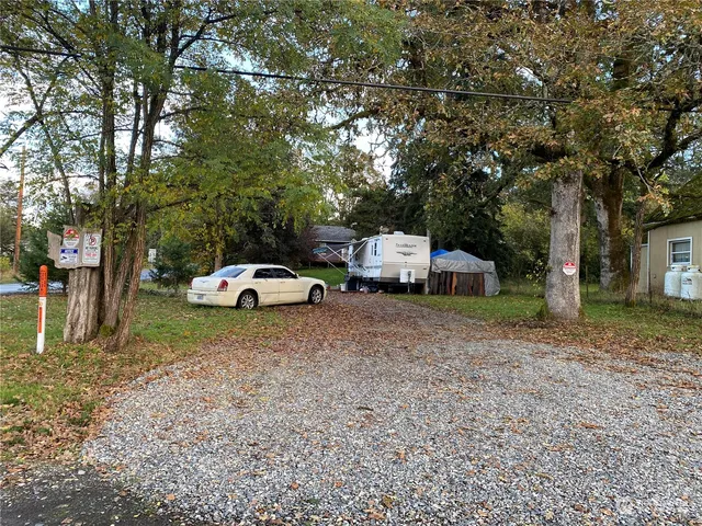 a car parked in front of a house and a trees