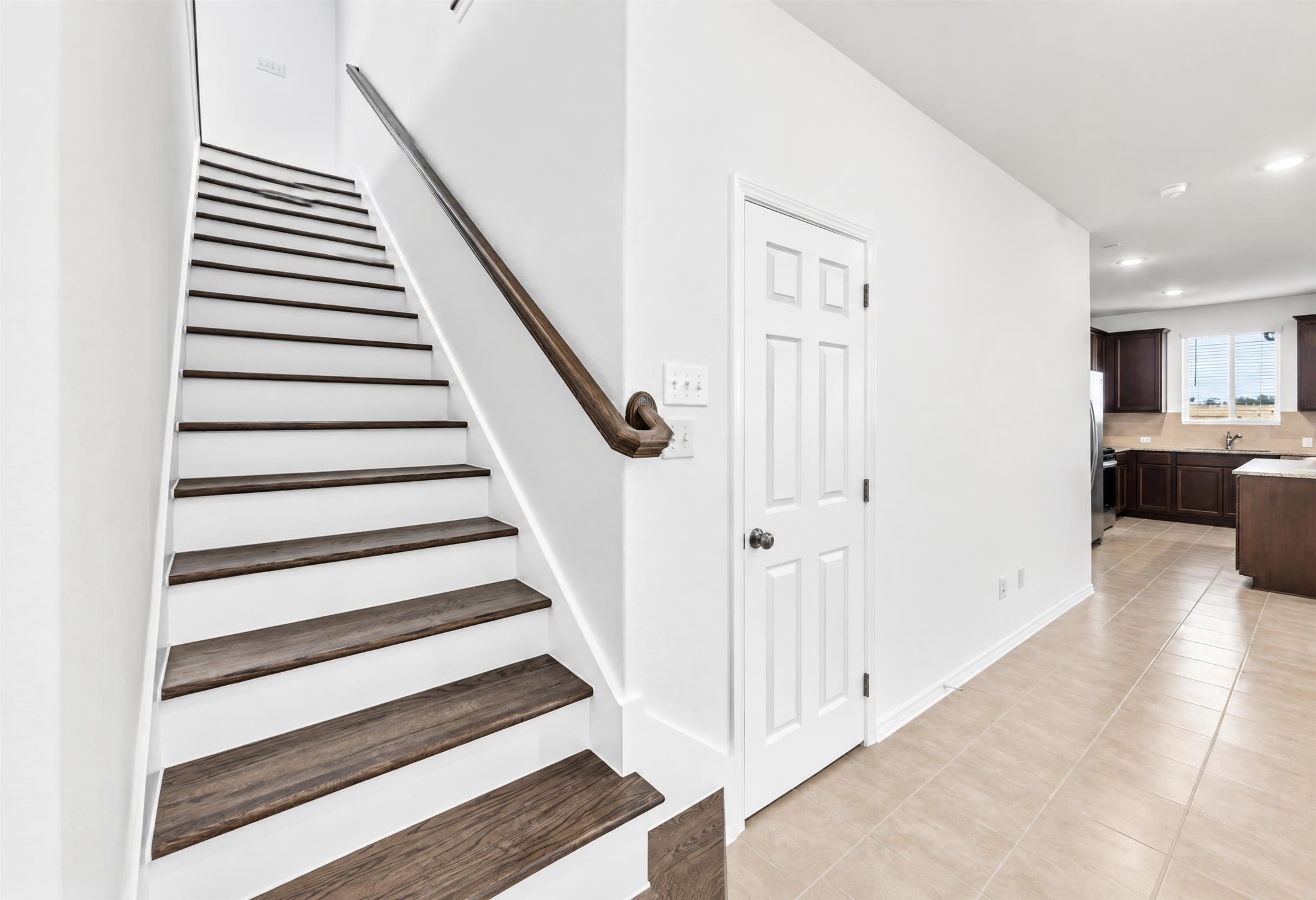 545 Henry Milton Road Georgetown, TX 78626 - Photo 7 of 33 Gleaming tile floors and a classic staircase with rich wood treads guide the way upstairs.