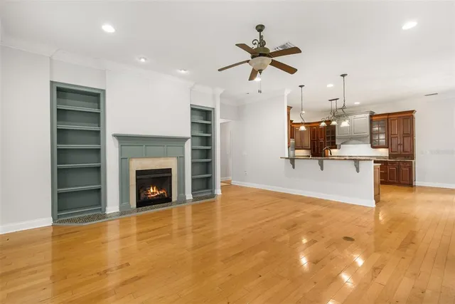 a view of an empty room with window and wooden floor