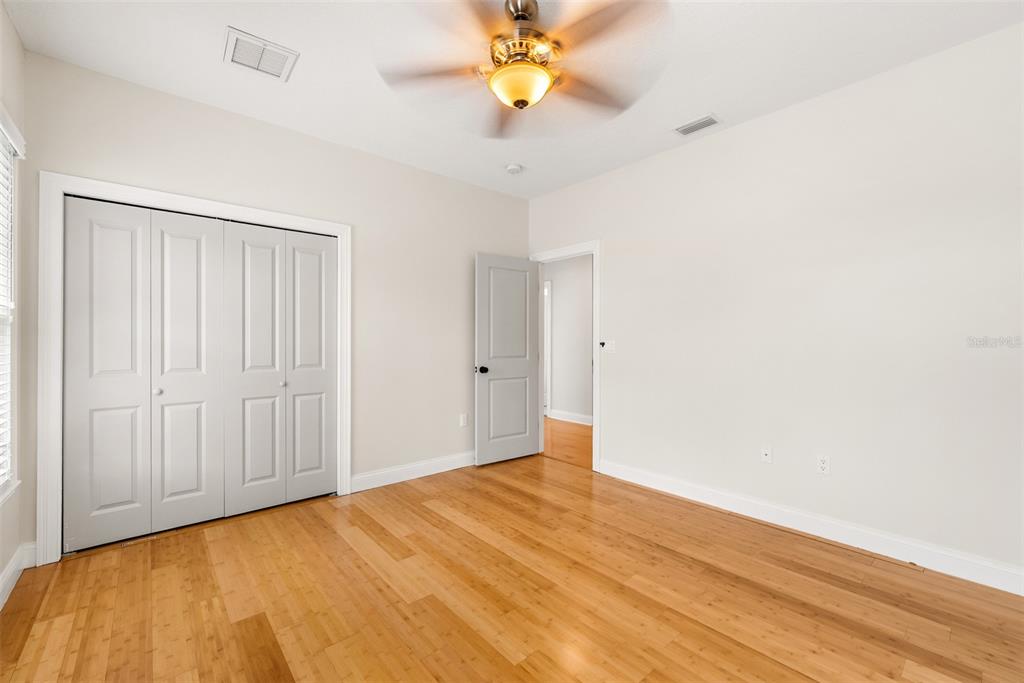 11067 Northwest 18th Road Gainesville, FL 32606 - Photo 46 of 58 a view of a bedroom with wooden floor and a ceiling fan