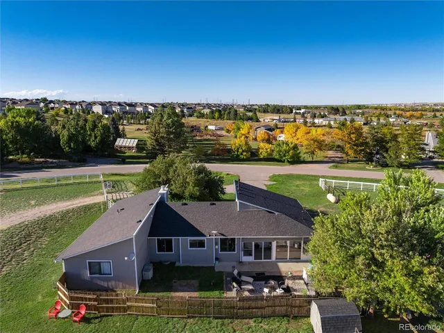 an aerial view of house with yard space and lake view in back