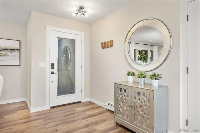 an entryway with wooden floor mirror and a wooden floor
