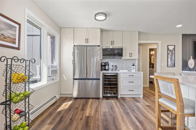 a kitchen with granite countertop a refrigerator and a stove top oven