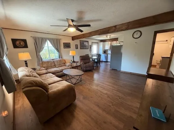 a kitchen with stainless steel appliances granite countertop a dining table chairs and a refrigerator
