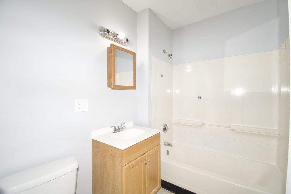 80-82 Silver Street Springfield, MA 01107 - Photo 23 of 31 a bathroom with a bathtub sink vanity and a mirror