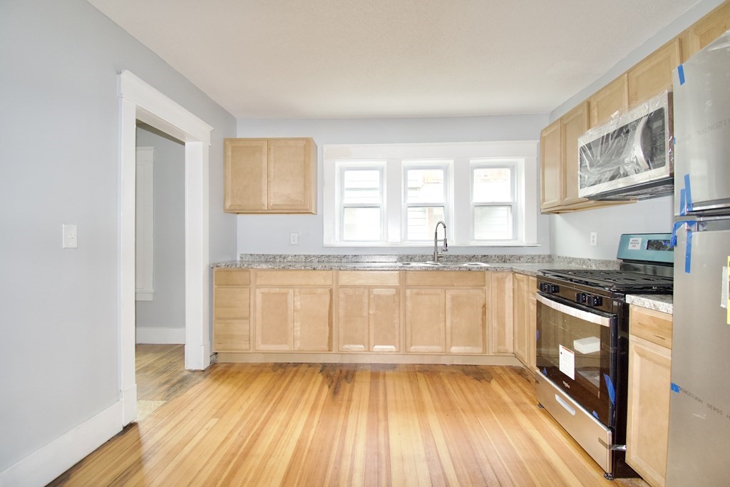 80-82 Silver Street Springfield, MA 01107 - Photo 25 of 31 a kitchen with granite countertop wooden floors and wide window