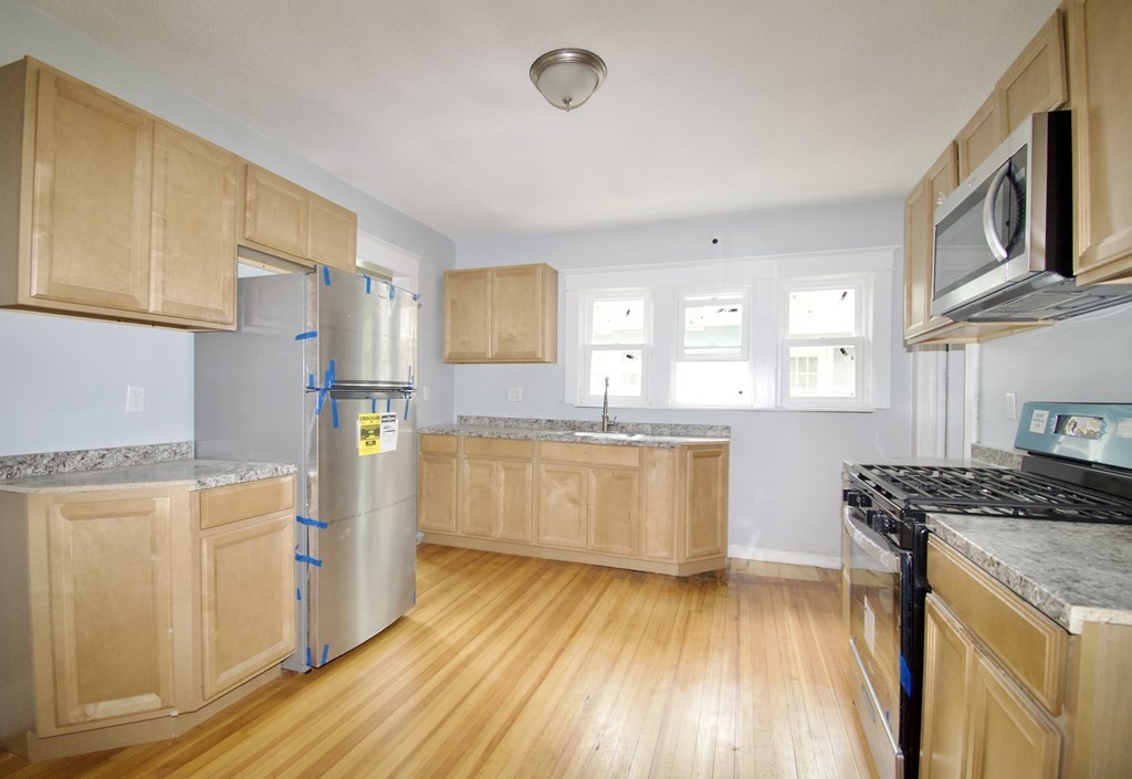80-82 Silver Street Springfield, MA 01107 - Photo 7 of 31 a kitchen with stainless steel appliances granite countertop a stove a sink and a refrigerator
