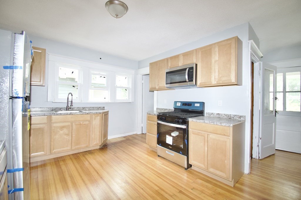80-82 Silver Street Springfield, MA 01107 - Photo 8 of 31 a kitchen with stainless steel appliances granite countertop a stove a sink and a microwave