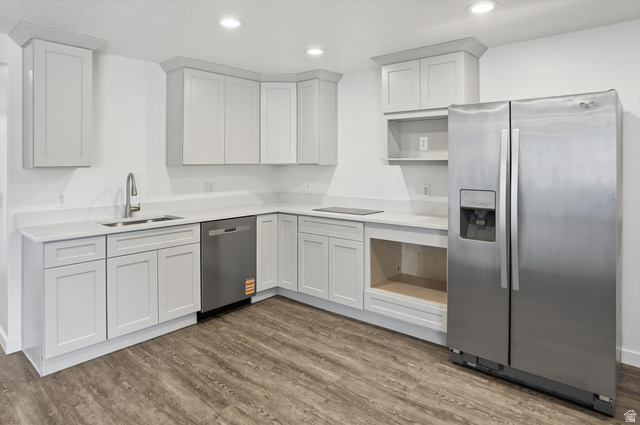3636 West 910 South Syracuse, UT 84075 - Photo 46 of 70 Modern kitchen featuring white shaker cabinetry, light-toned countertops, stainless steel appliances, and wood-finish flooring