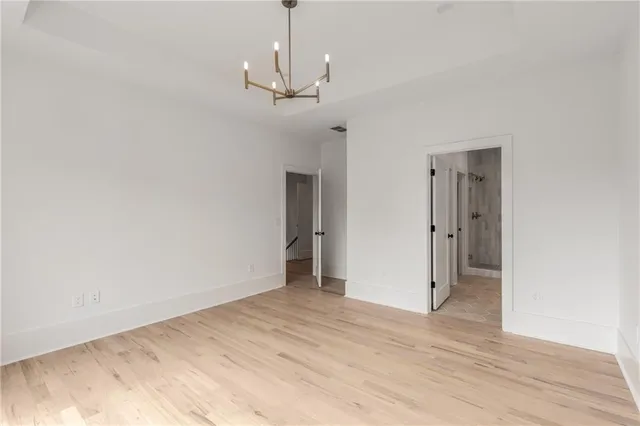 a view of an empty room with window and wooden floor